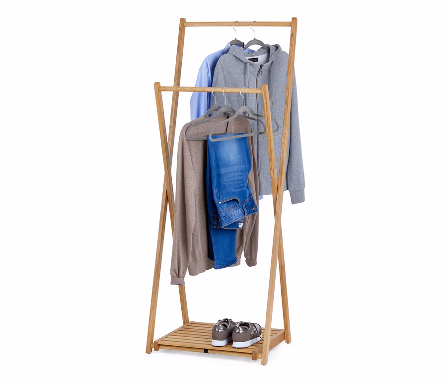 Ein klappbarer Massivholz-Kleiderständer mit Hemd, Hoodie, Pullover und Jeans auf Kleiderbügeln. Schuhe stehen auf der unteren Ablage.