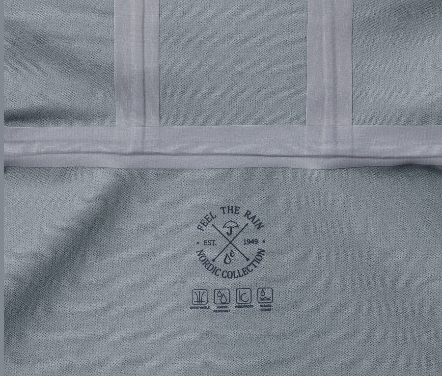 Detailansicht eines grauen Hardshell-Regenparkas mit Nordic Collection-Logo.