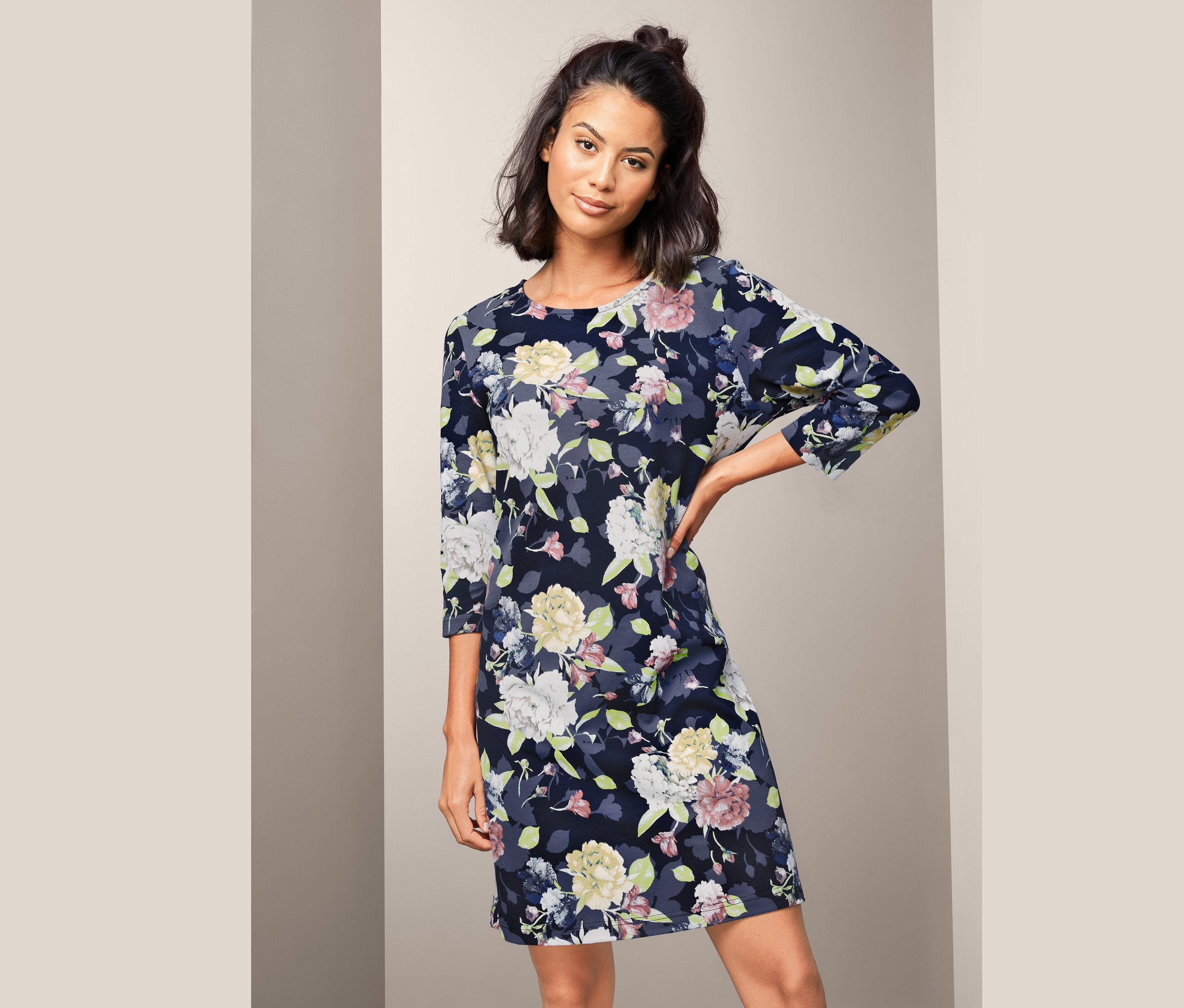 Frau posiert in einem Nachthemd mit Blumenmuster.