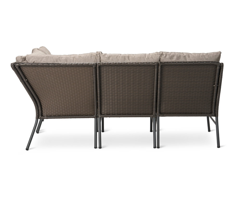 Rückansicht einer Loungeecke mit Polyrattangeflecht und beigen Kissen.