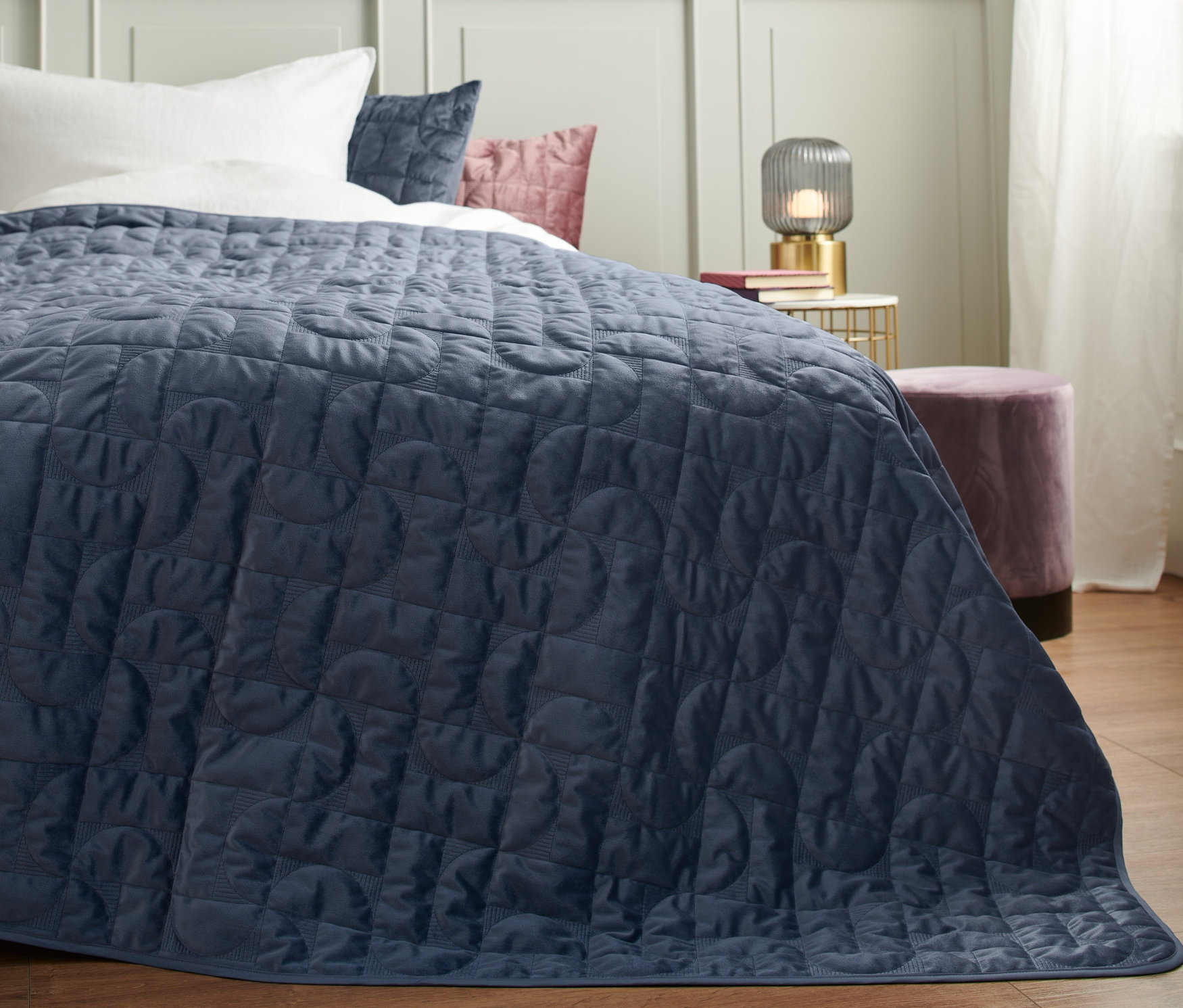 Ein blauer Bettüberwurf liegt auf einem Bett.