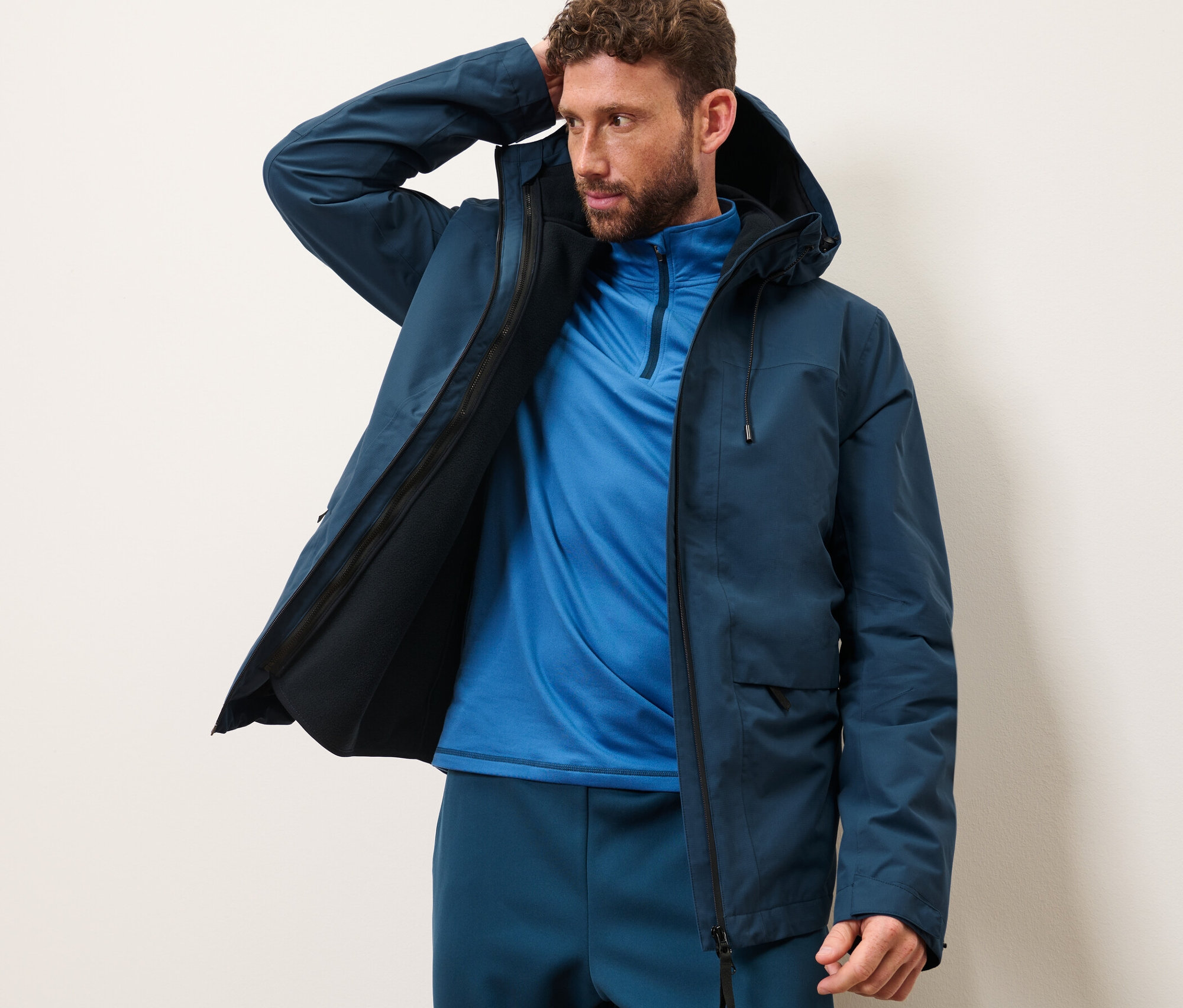 Mann posiert in Outdoorjacke mit Weste.