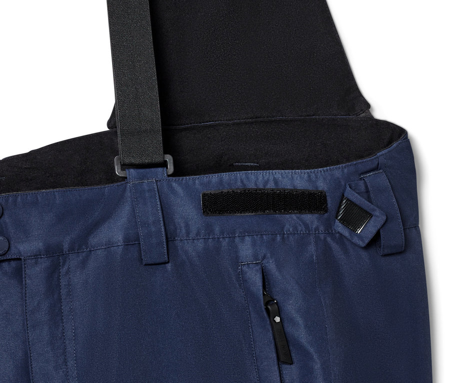 Detail einer blauen Skihose mit schwarzen Hosenträgern.