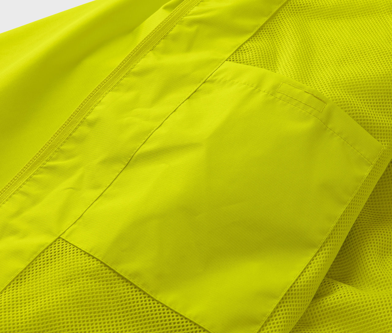 Detailansicht einer gelben Regenjacke mit Tasche.