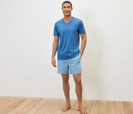 Mann posiert in einem Shorty-Pyjama-Set.