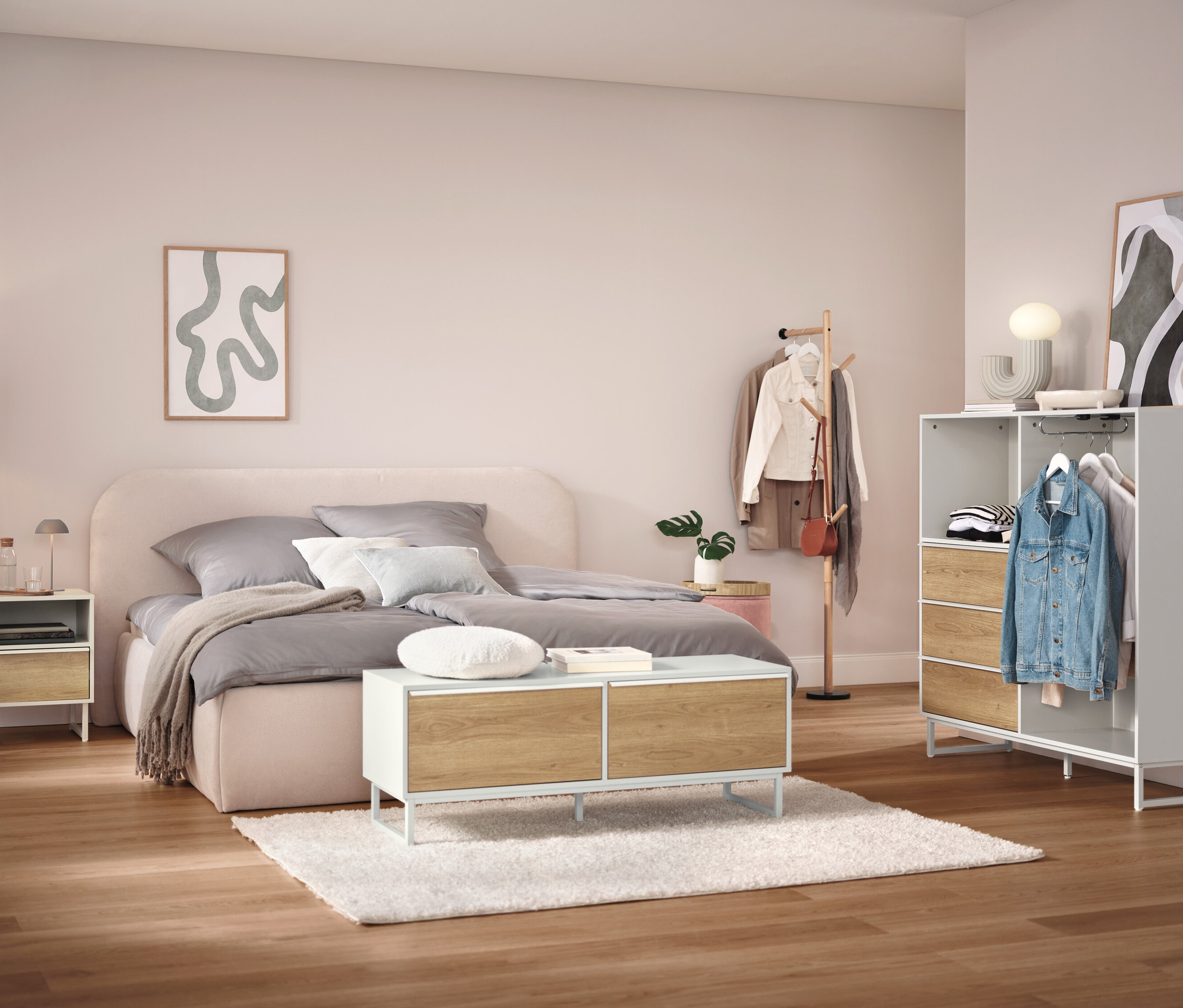 Schlafzimmer mit Bett, Nachttisch, Schrank und Kleiderständer.