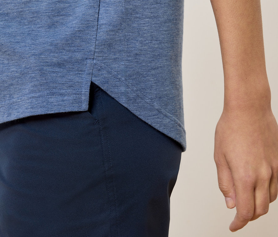 Nahaufnahme einer Person, die ein blaues T-Shirt und marineblaue Hosen trägt.