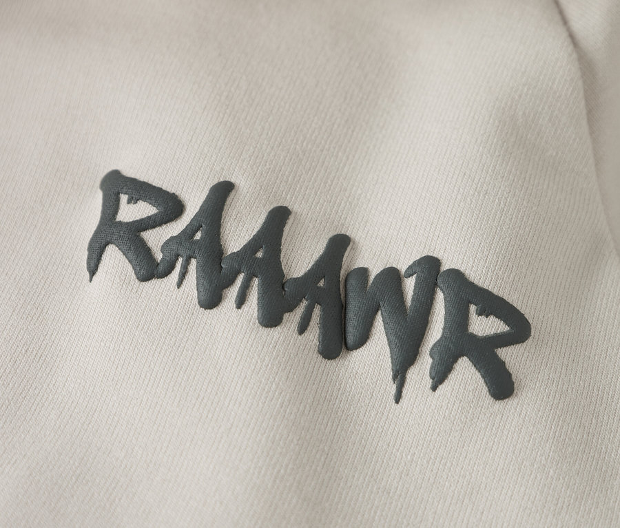 Nahaufnahme eines hellbeigen Hoodies mit dem grauen Aufdruck "RAAAWR".