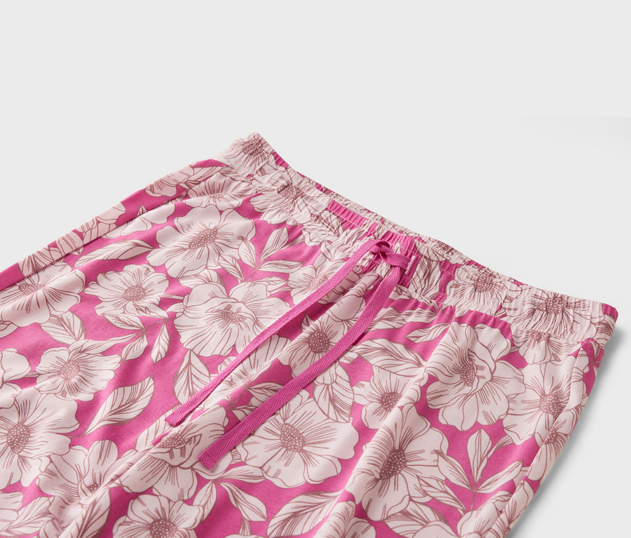 Nahaufnahme einer pinkfarbenen Hose mit Blumenmuster und pinkfarbenem Kordelzug.