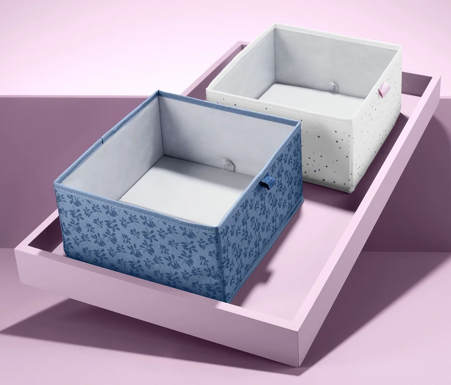 Zwei quadratische Schubladen-Ordnungsboxen auf einem rosa Tablett.