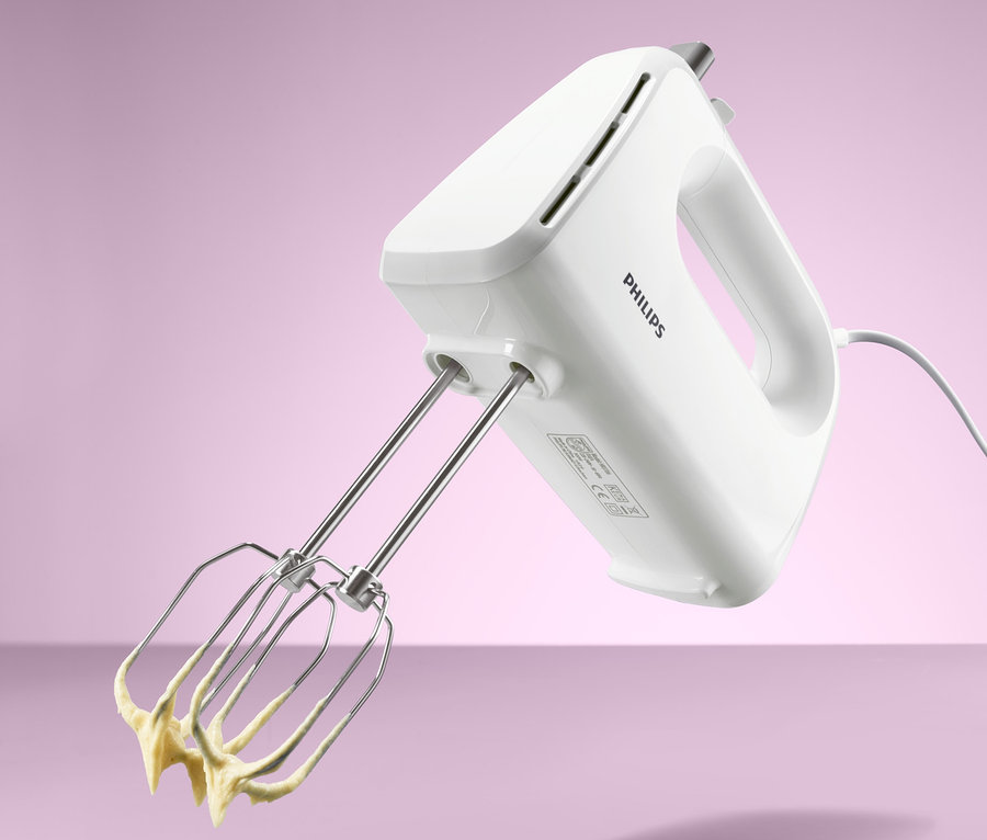 Weißer Philips-Handmixer HR 3706 mit Edelstahl-Rührbesen, an denen gelber Teig hängt.