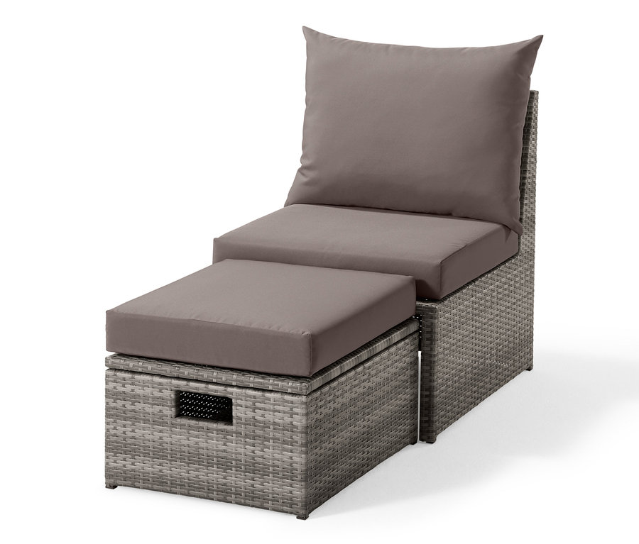Grauer Loungesessel mit Fußteil aus Polyrattan mit grauen Kissen.