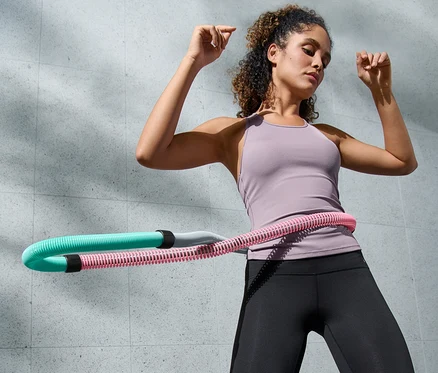 Frau trainiert mit flexiblem Fitnessreifen.