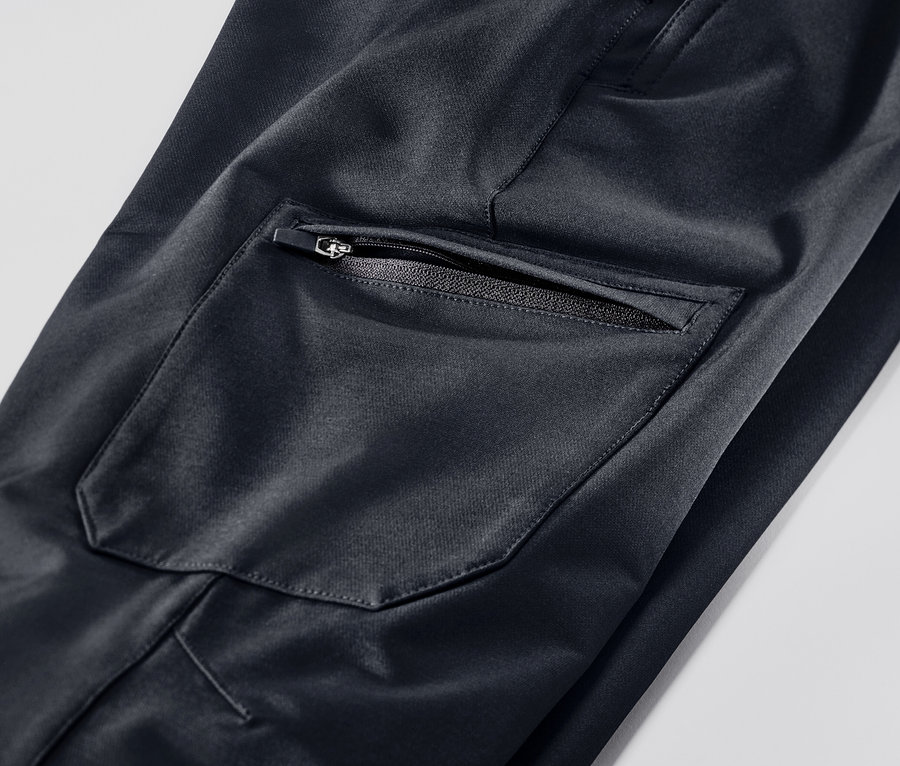 Detail einer schwarzen Cargo-Softshellhose mit Reißverschlusstasche.