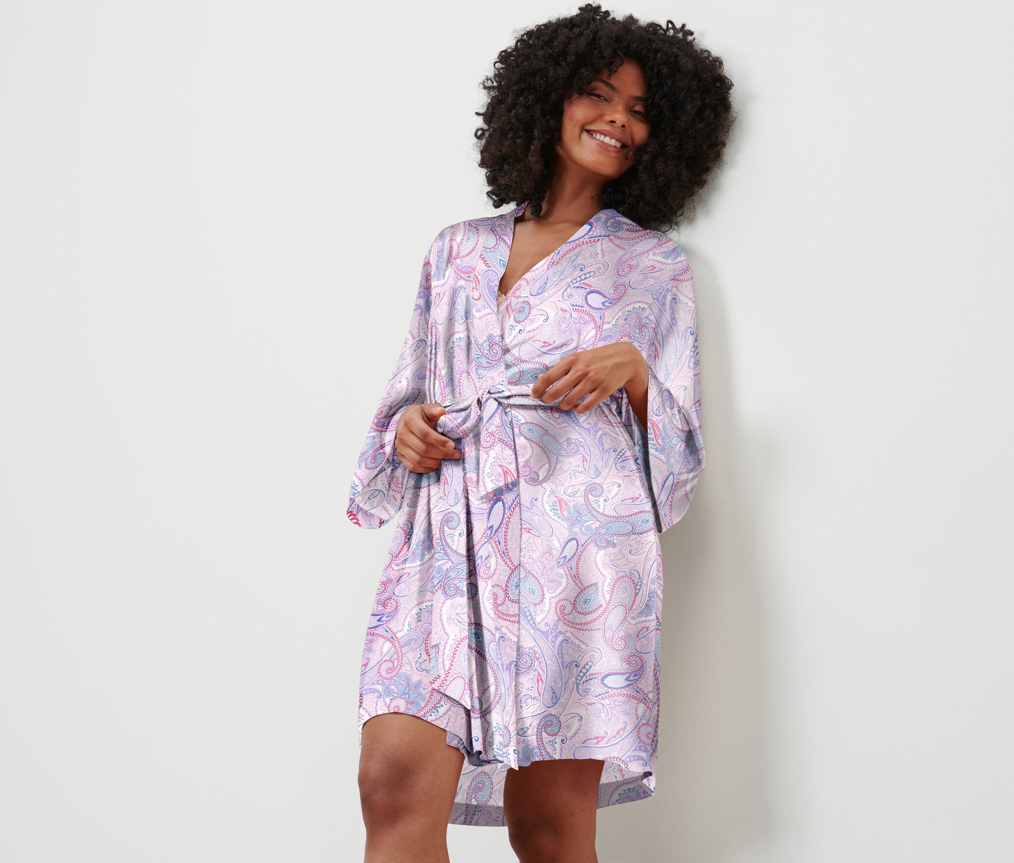 Frau bindet Morgenmantel mit Paisley-Muster.