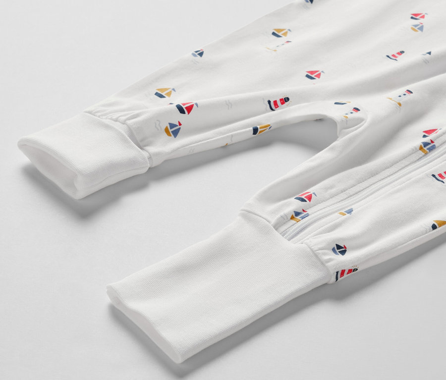 Detailansicht eines weißen Baby-Pyjamas mit maritimen Motiven.