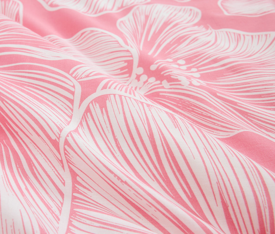 Detailaufnahme eines rosafarbenen Stoffes mit weißem Blumenmuster.
