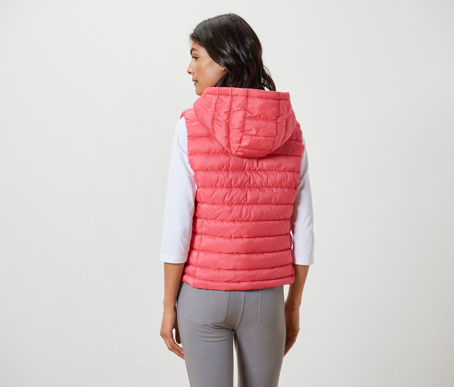 Frau trägt eine Steppweste mit Kapuze.