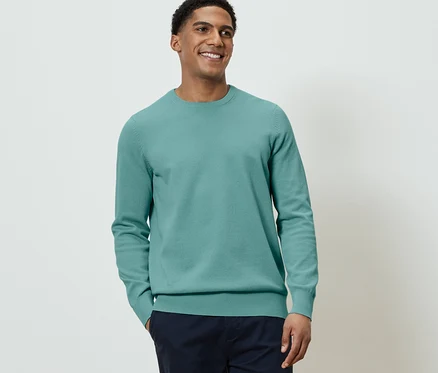 Mann trägt Strick-Pullover.