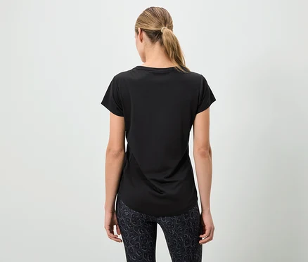 Frau von hinten trägt ein schwarzes T-Shirt und gemusterte Leggings.