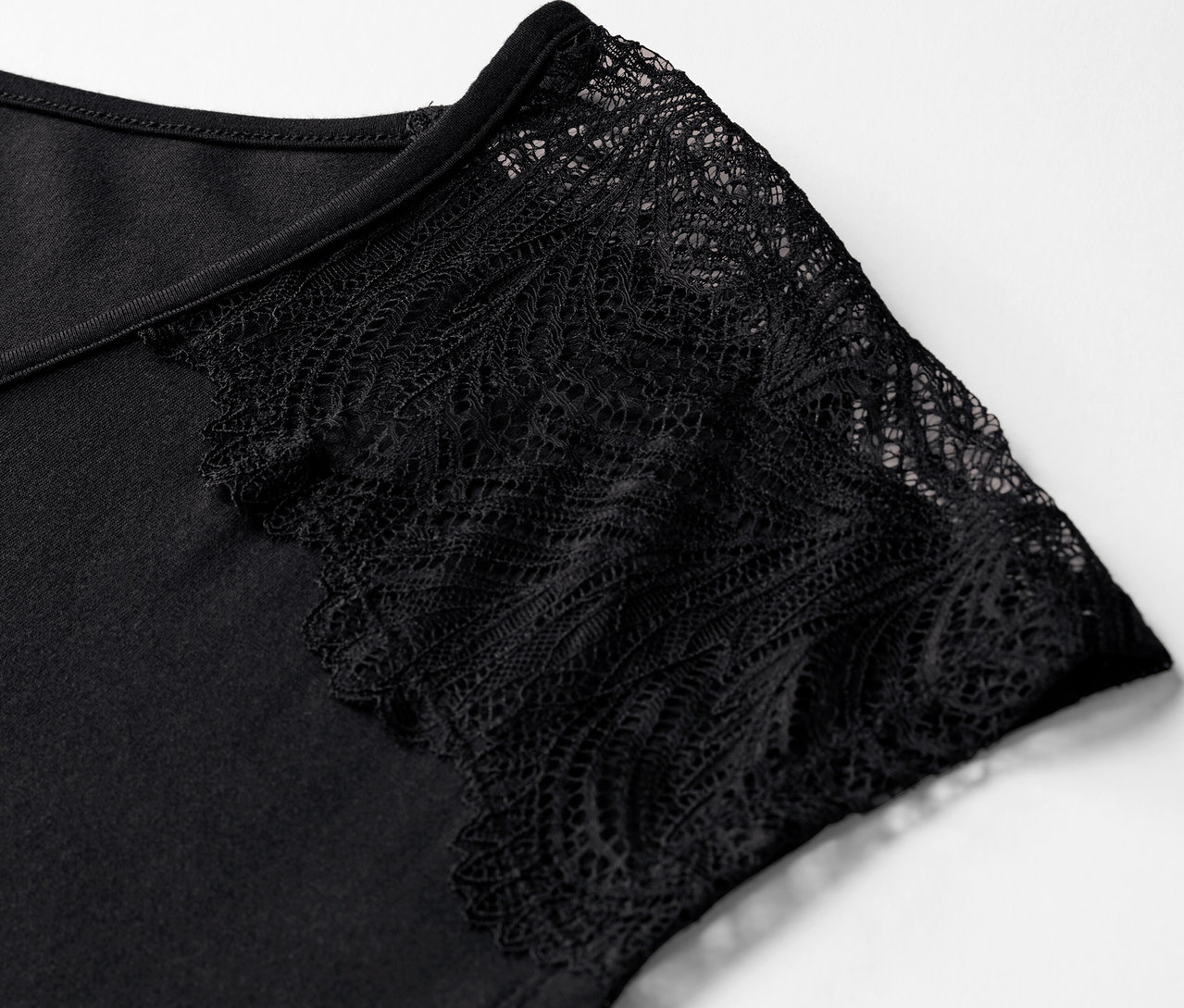 Detailaufnahme eines schwarzen Shorty-Pyjamas mit Ärmelspitze.