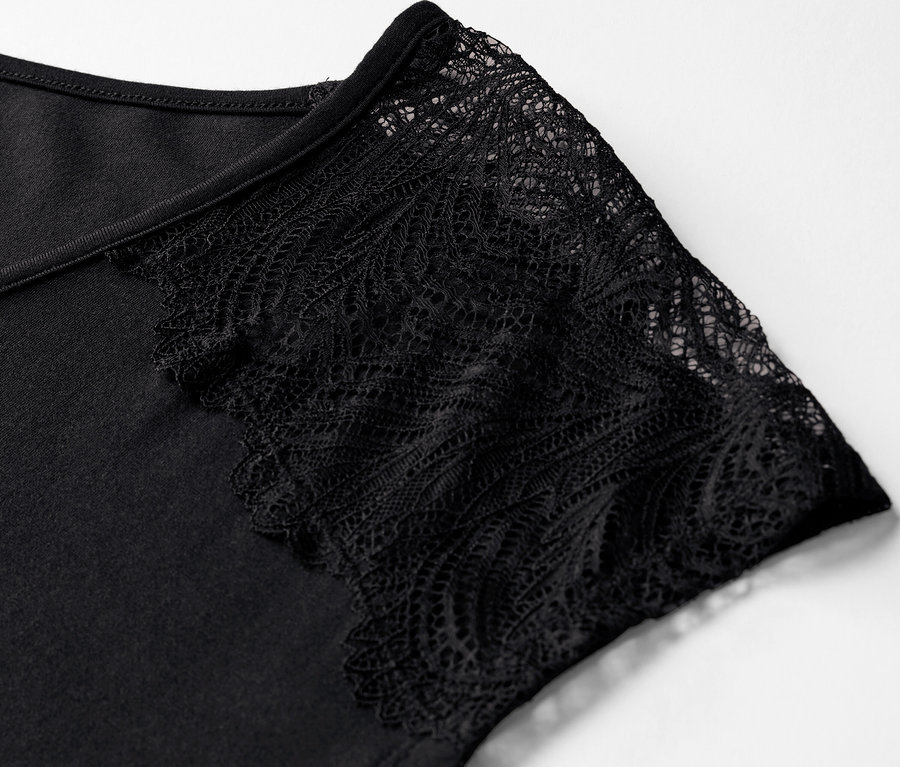 Detailaufnahme eines schwarzen Shorty-Pyjamas mit Ärmelspitze.