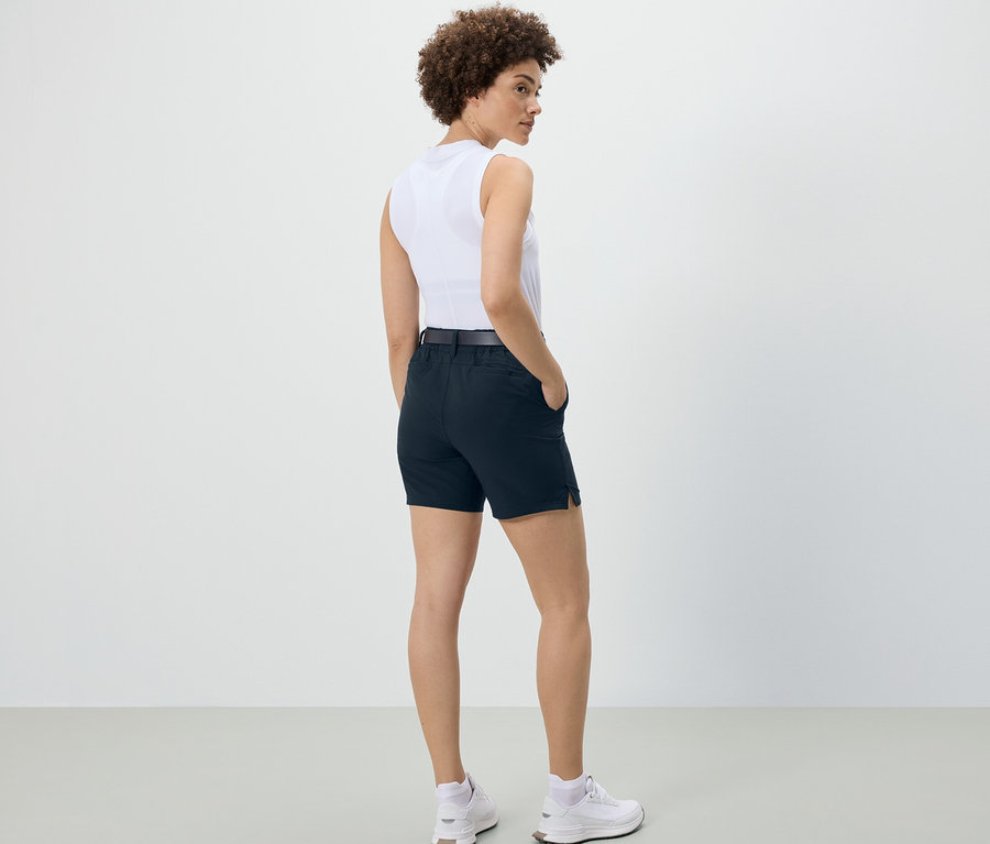 Eine Frau steht mit dem Rücken zur Kamera und trägt dunkelblaue Softshell-Funktionsshorts.