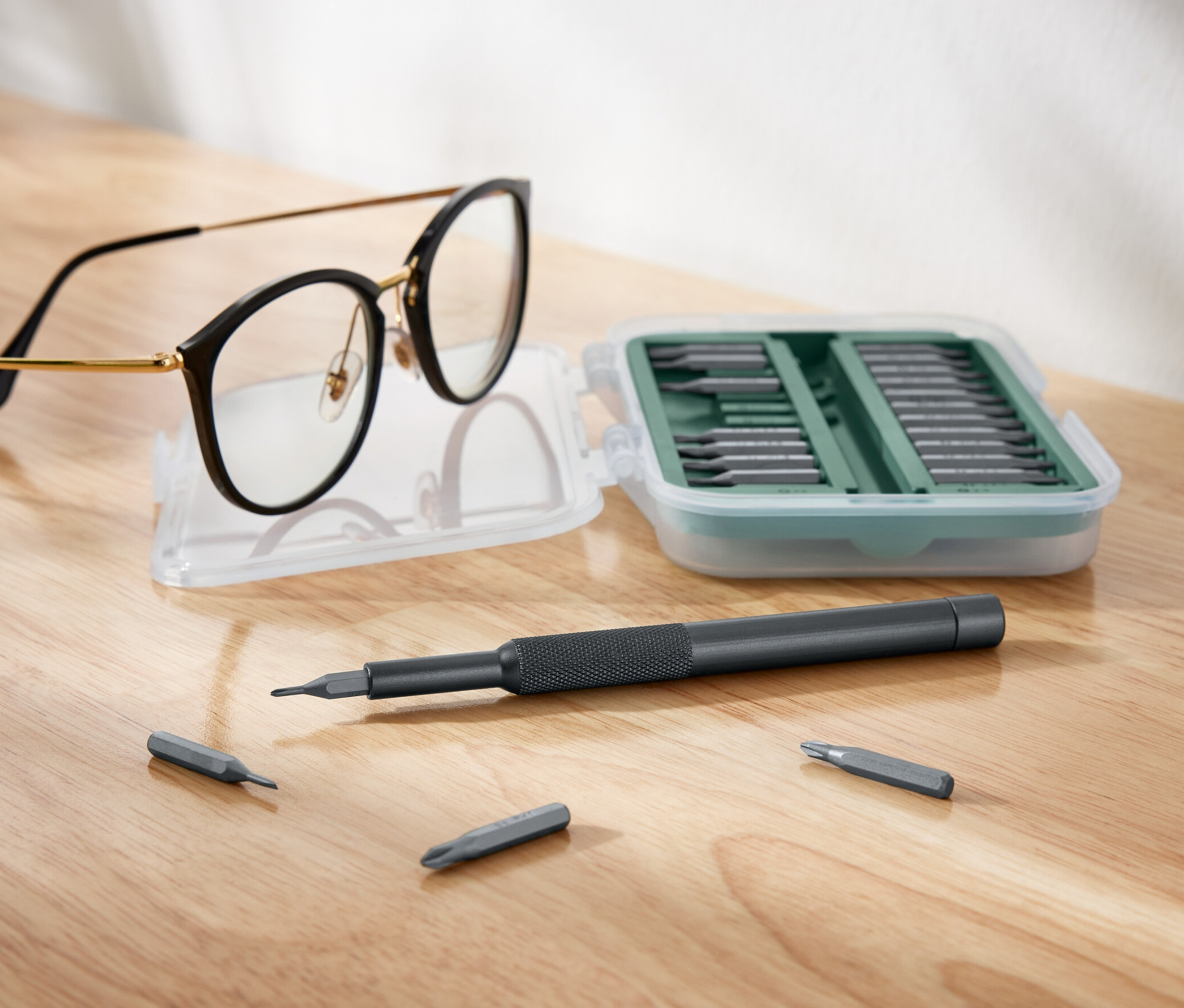 Brille liegt neben offenem Präzisions-Schraubendreher-Set.