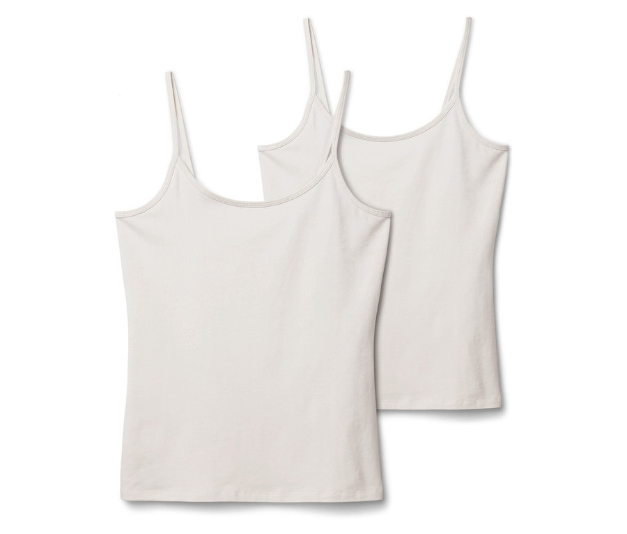 Zwei weiße Tanktops mit dünnen Trägern liegen nebeneinander auf einem weißen Hintergrund.