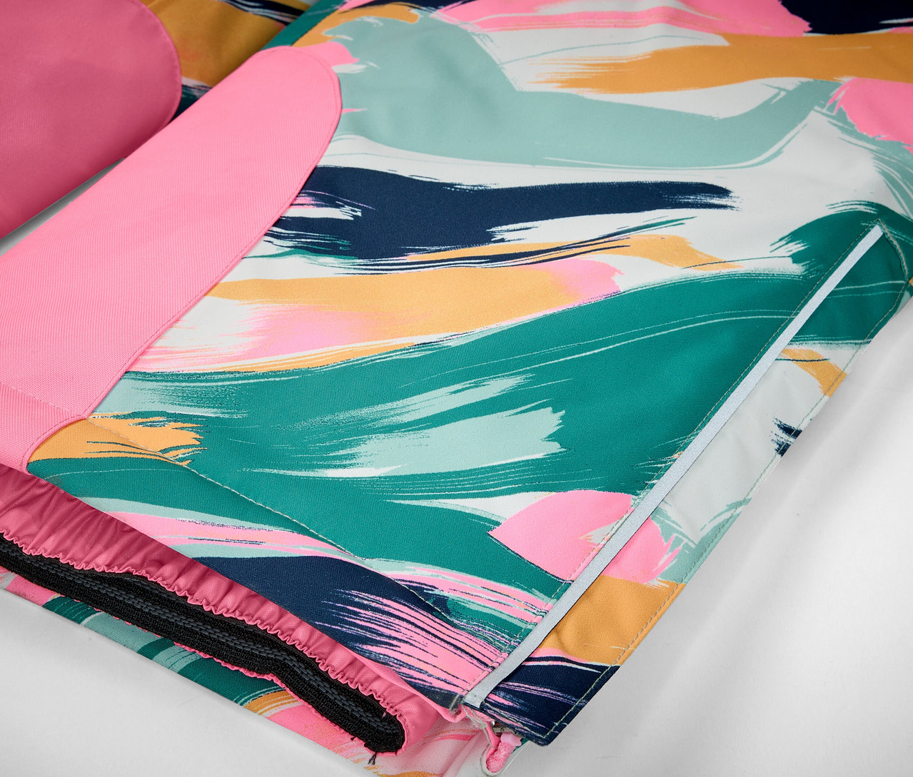 Detail einer Jacke mit farbigen Pinselstrichen in Grün-, Blau-, Rosa- und Gelbtönen.