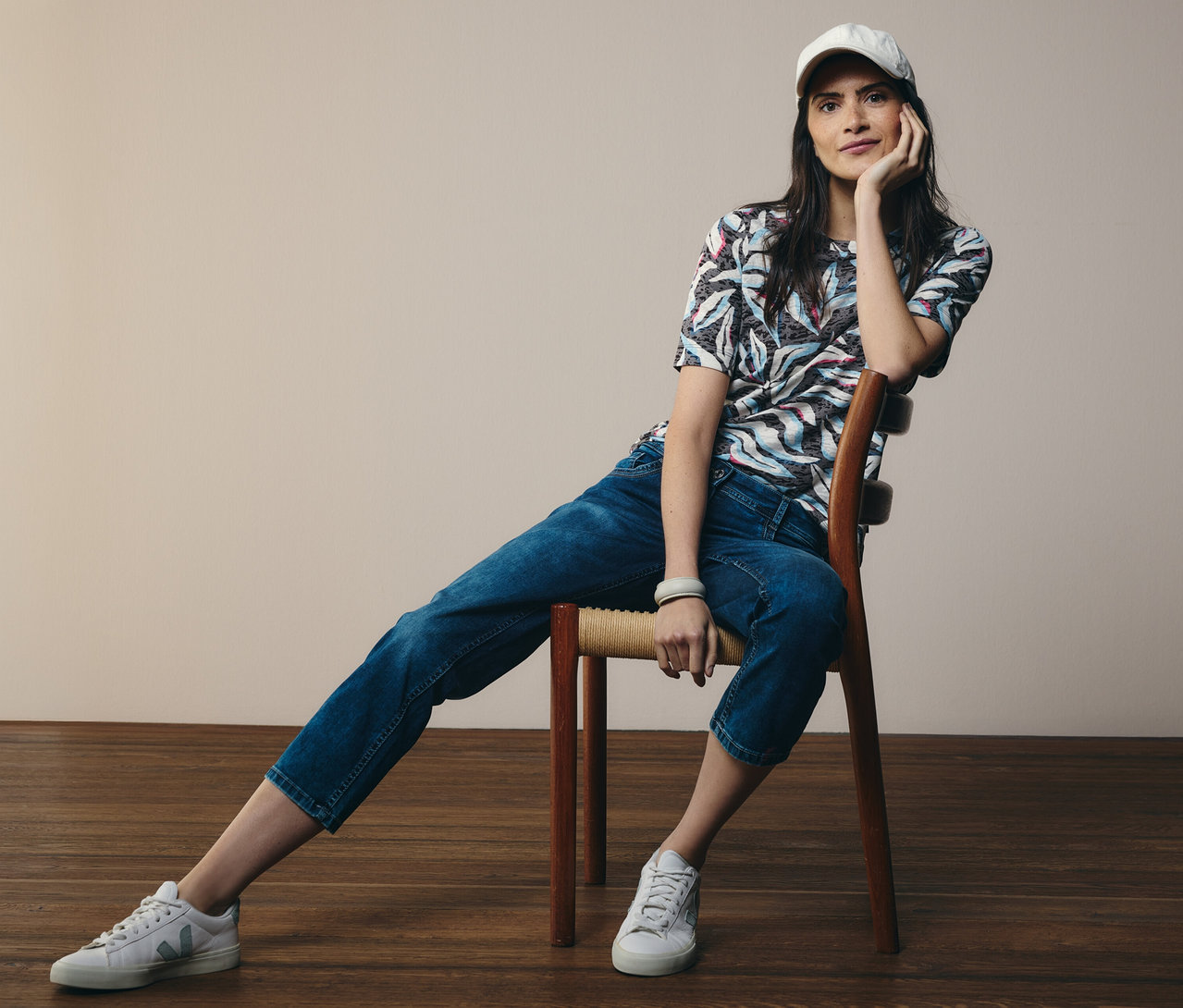 Frau sitzt auf einem Stuhl, trägt ein blaues CECIL Kurzarmshirt und CECIL Jeans »Scarlett«.