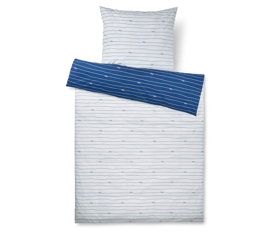 Draufsicht auf ein Bett mit weiß-grau gestreifter Bettwäsche und Kissen sowie einer blau-weiß gestreiften Decke.