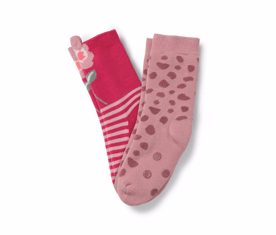 Zwei Paar Socken: ein Paar rosa mit Blumenmuster und Streifen, das andere hellrosa mit braunen Punkten.