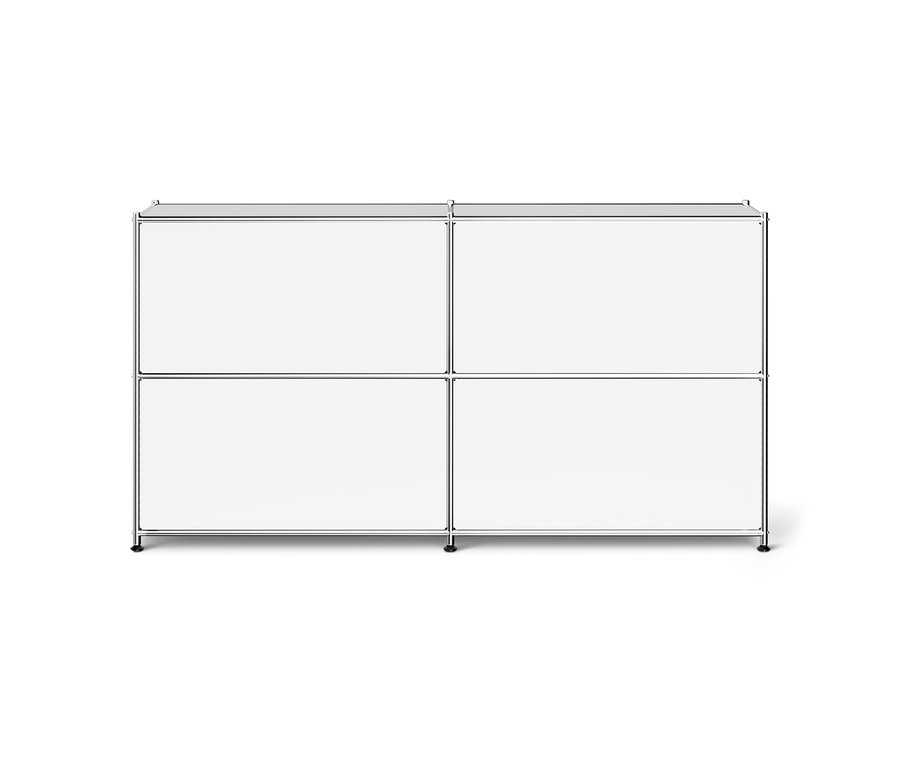 Ein weißes, modulares Aufbewahrungsmöbel mit Chromrahmen. Es hat vier geschlossene Fächer, die in zwei Reihen und zwei Spalten angeordnet sind, und steht auf kleinen schwarzen Füßen.