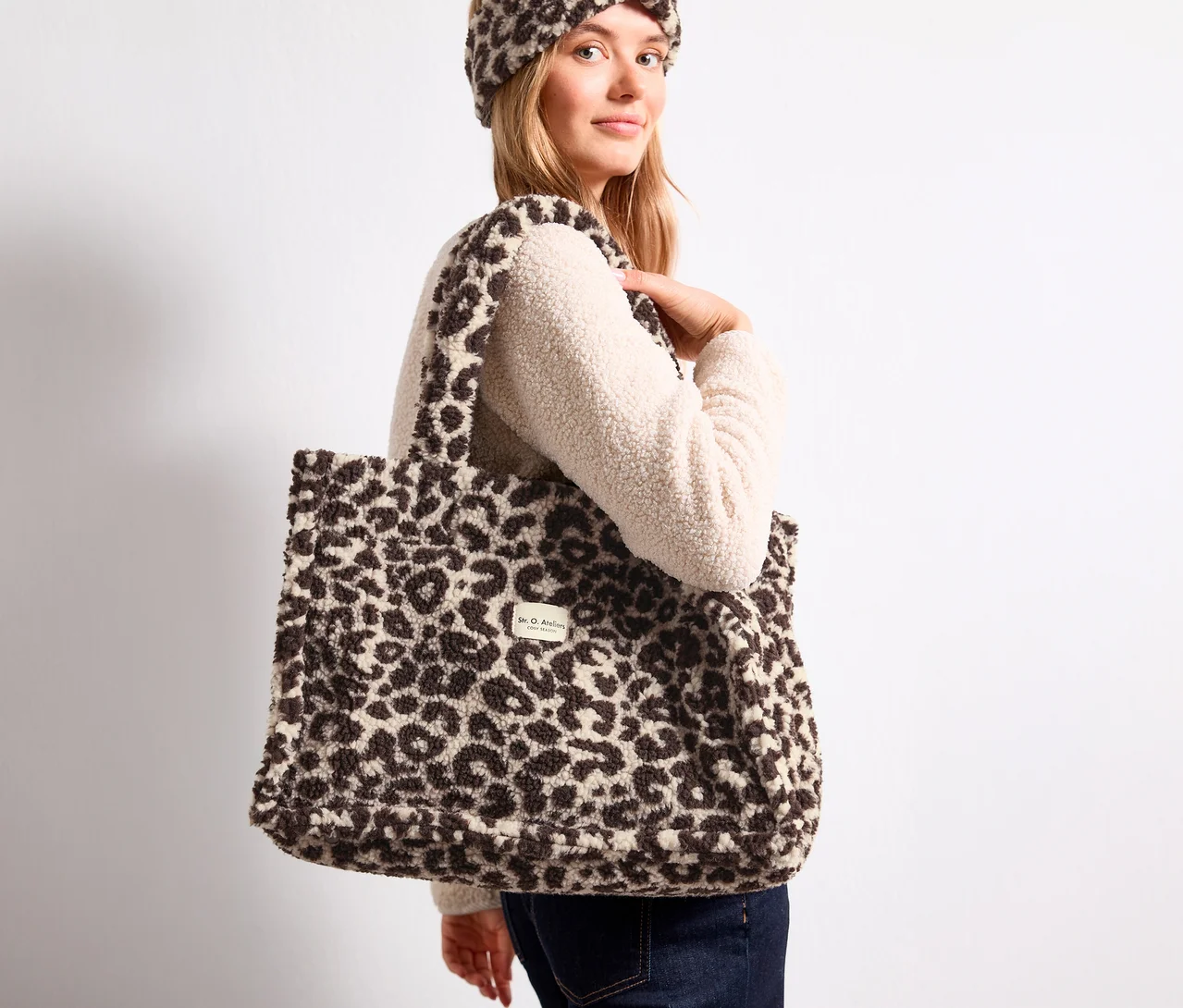 Blonde Frau trägt einen flauschigen Street One Shopper mit Leopardenmuster auf der Schulter und ein passendes Stirnband.
