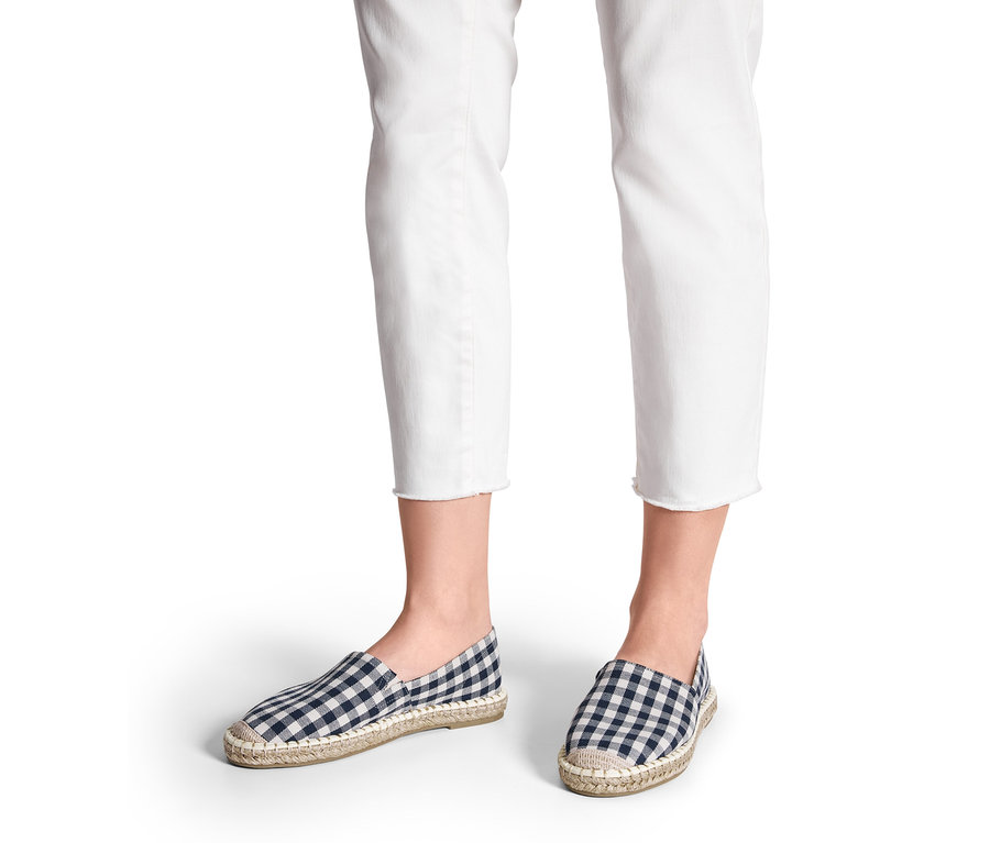 Beine in weißen Jeans, die Espadrilles tragen.