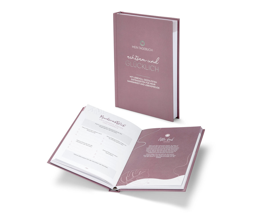 Ansicht eines offenen Buches "Mein Tagebuch ‒ achtsam und Glücklich" mit Blick auf die Innenseiten und einem zweiten Exemplar dahinter.