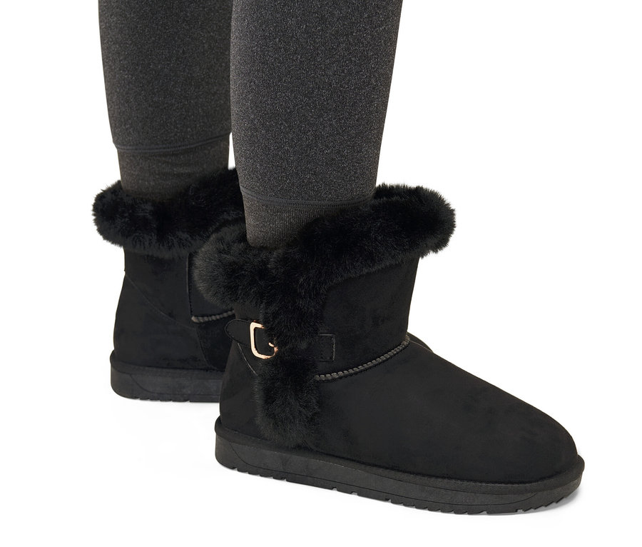 Beine in schwarzen gefütterten Boots.