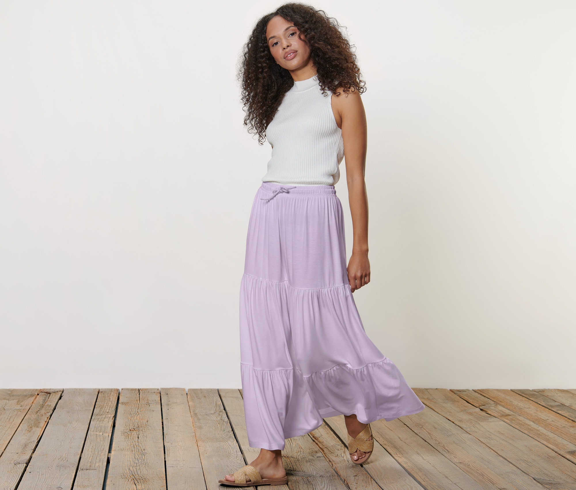 Frau posiert in Maxi-Rock und weißem Top.