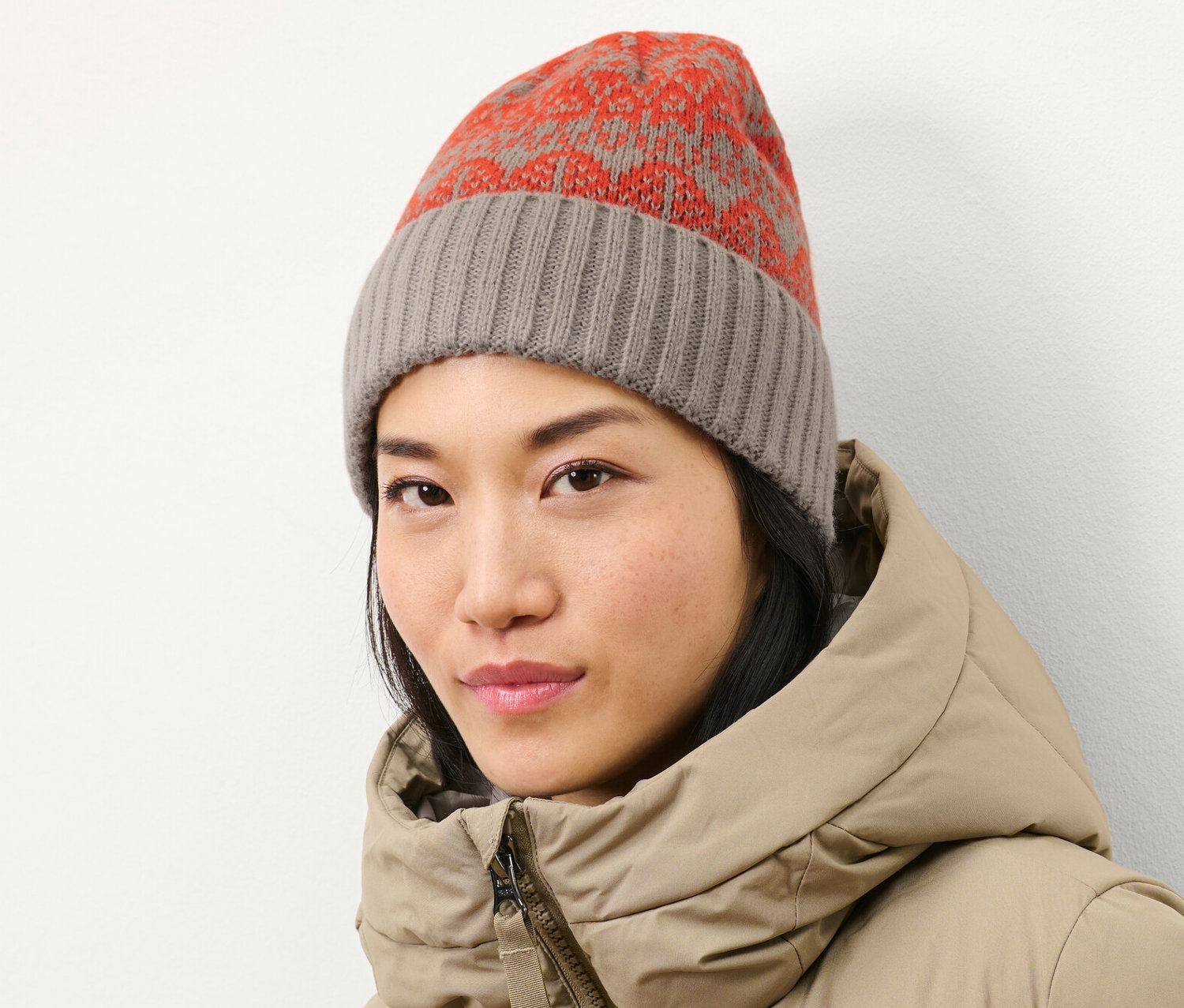 Frau trägt eine Strickmütze und eine Daunenjacke.