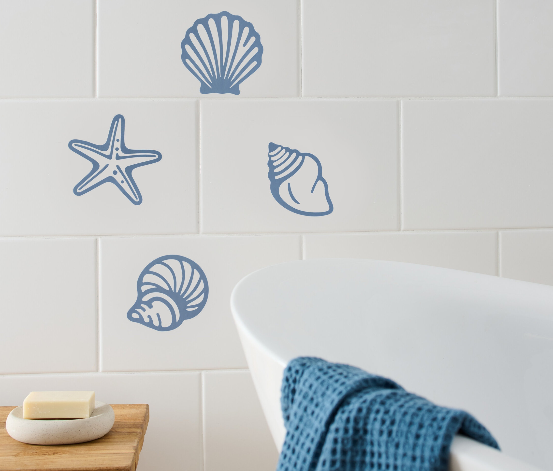 Maritime Fliesenaufkleber auf weißen Fliesen im Badezimmer.