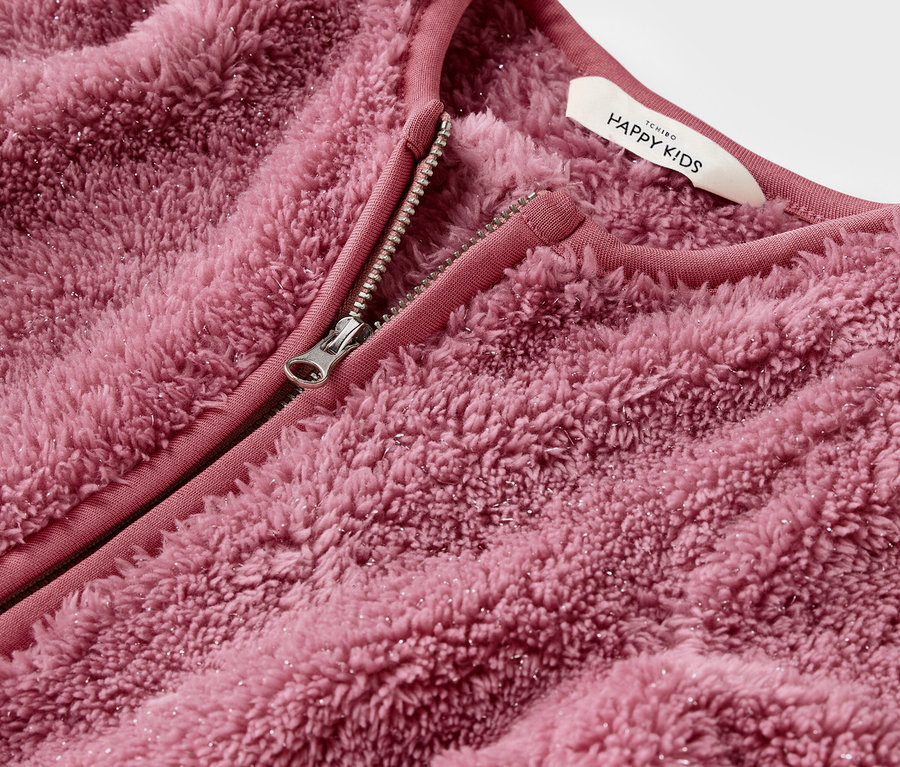 Detailaufnahme einer rosa, flauschigen Jacke mit offenem Reißverschluss.