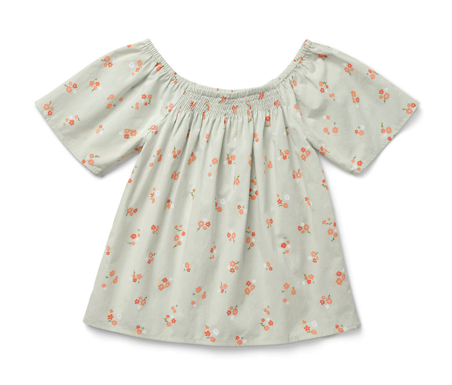 Eine Kinder-Bluse mit Blumenmuster auf hellem Hintergrund.