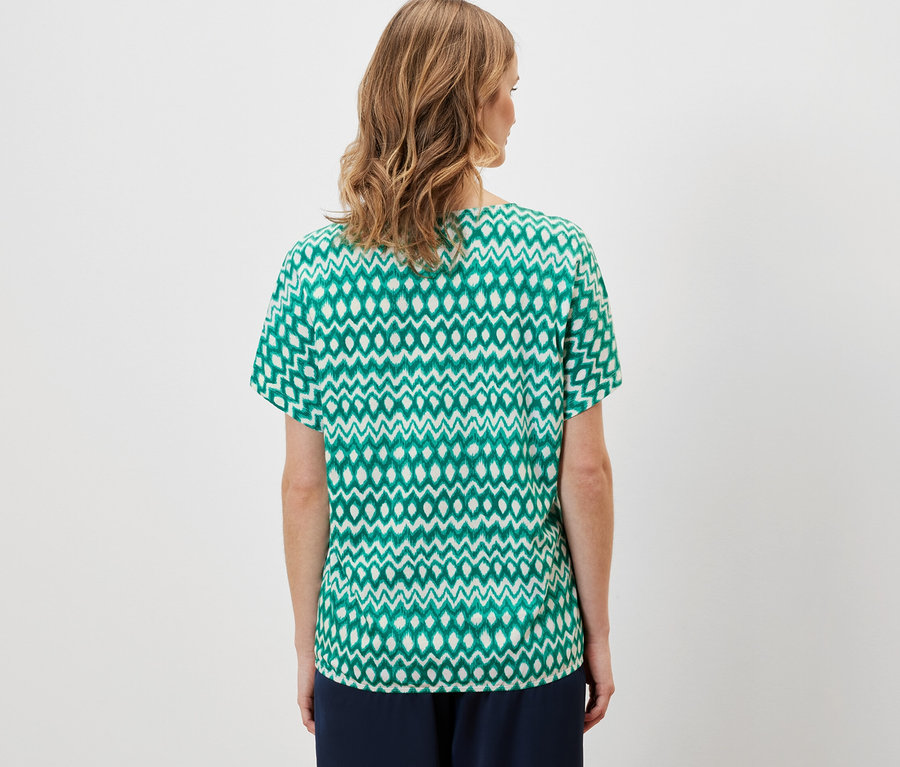 Frau trägt bedrucktes Blusenshirt.