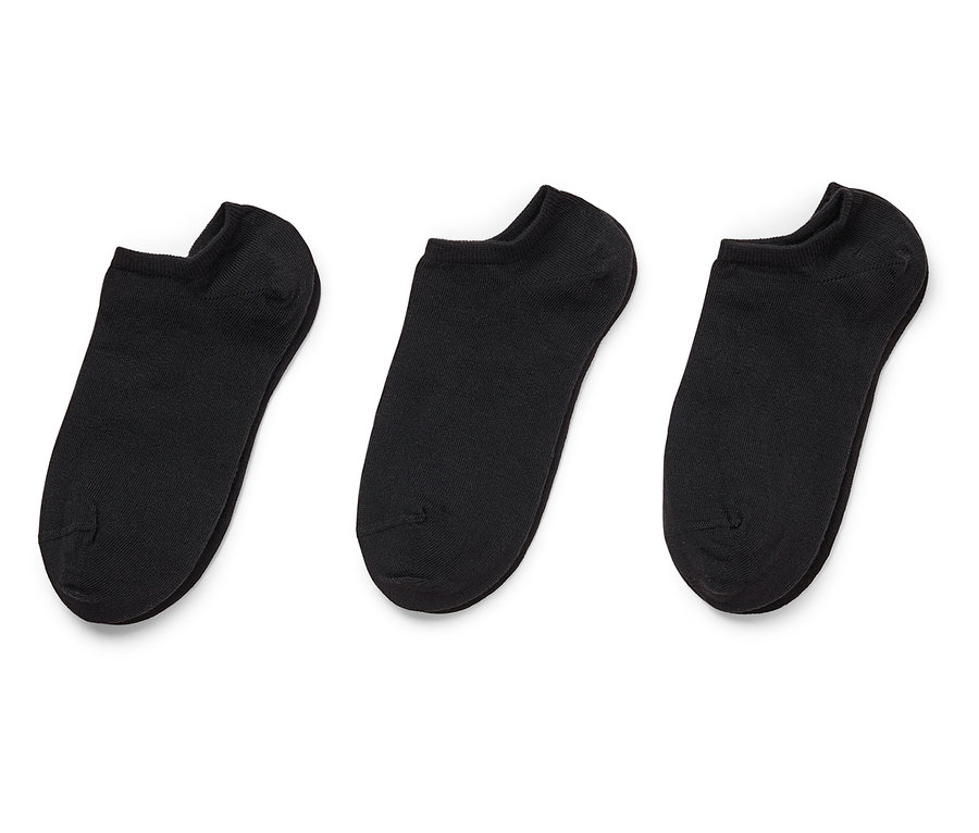 Drei schwarze, kurze Socken liegen nebeneinander auf einem weißen Hintergrund.