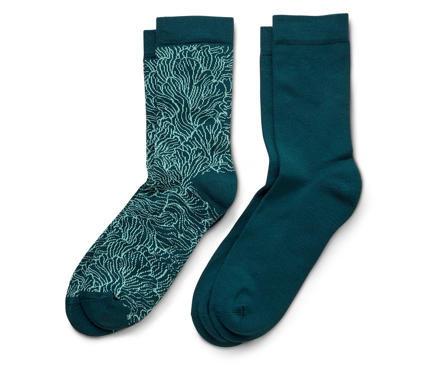 Ein Paar marineblaue Socken, eine mit einem hellblauen Muster und die andere einfarbig.