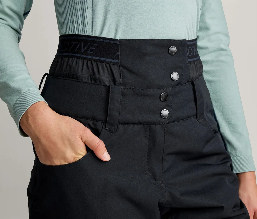 Person in hellblauem Langarmshirt und schwarzer High-Waist-Hose, die Hand in der Tasche. Die Hose hat einen breiten Knopfverschluss und ein Gummiband mit „ACTIVE“-Schriftzug.