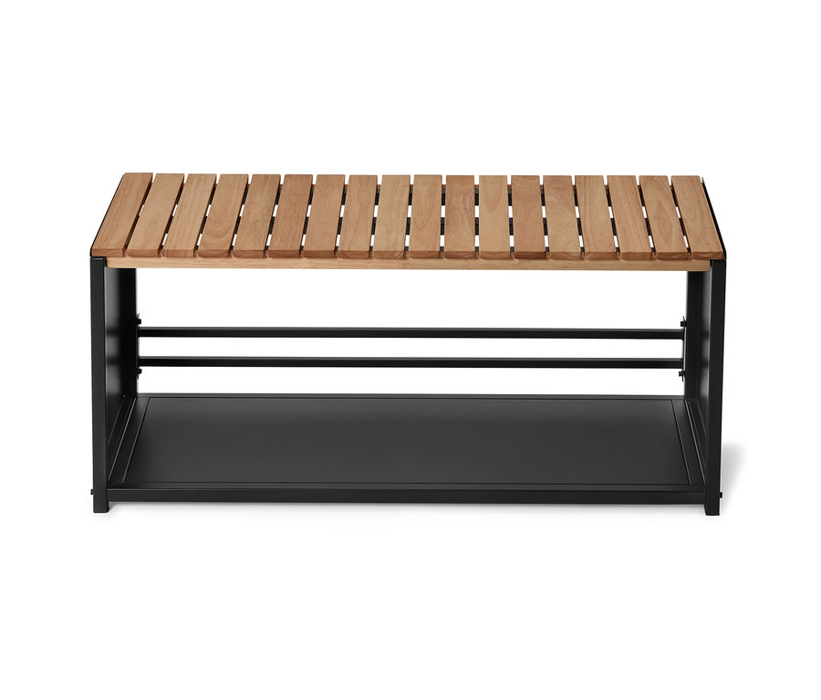 Eine Bank mit einer Sitzfläche aus hellem Holz und einem schwarzen Metallgestell mit einer Ablage.