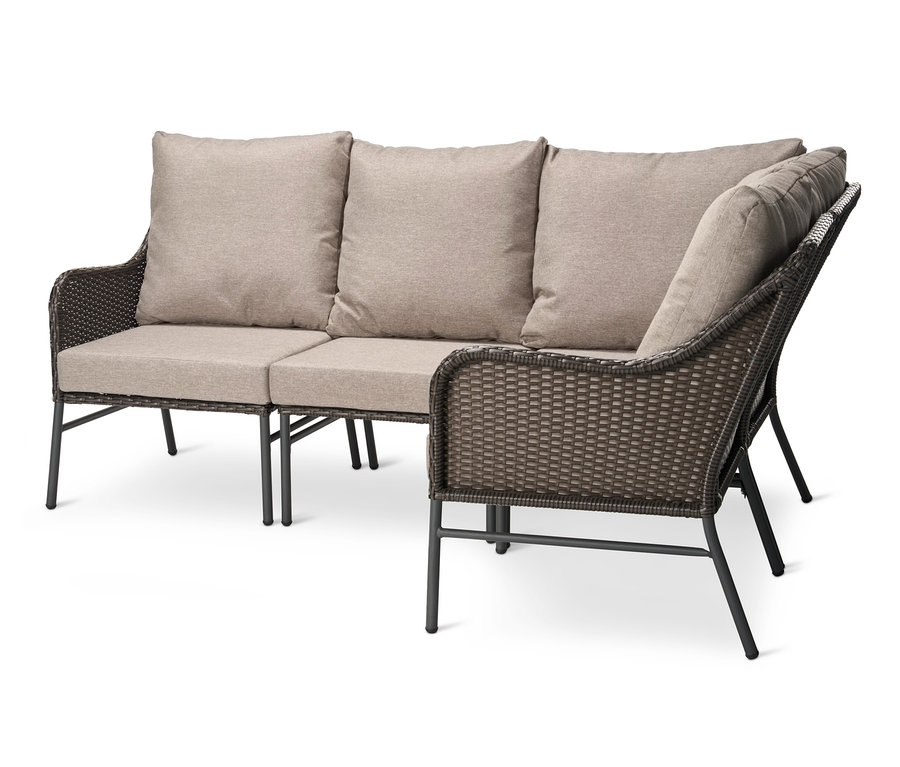 Eine Loungeecke mit Polyrattangeflecht und beigen Kissen.