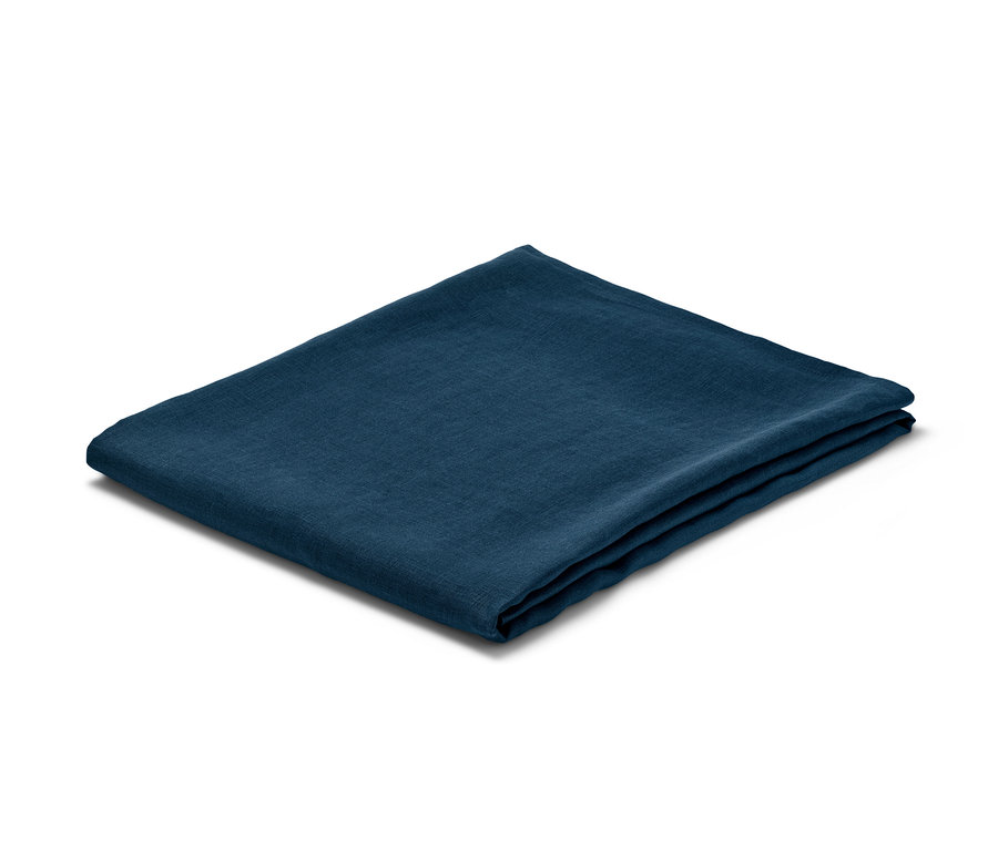 Eine dunkelblaue Leinen-Tafeldecke gefaltet auf einem weißen Hintergrund.